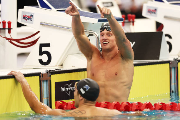 Grant House smiling and pointing from his lane after a swim